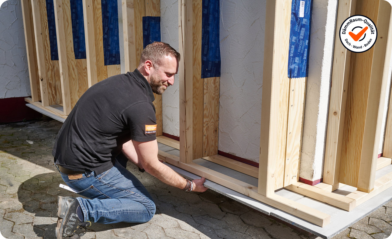Mann errichtet Unterkonstruktion für Fassadendämmung | B+M HolzWelt