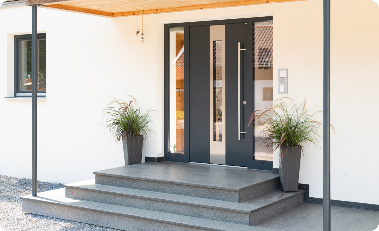 Dunkle Haustür mit Glaseinsatz und Seitenteilen hinter Treppeneingang | B+M HolzWelt