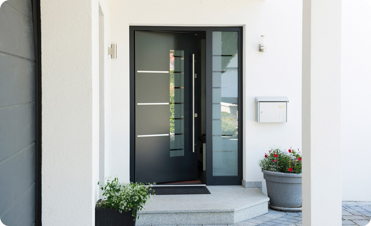 Leicht offenstehende schwarze Haustür mit Glaseinsätzen | B+M HolzWelt